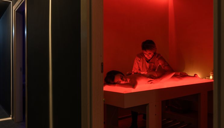 Una cliente del centro benessere del Resort La Battigia riceve un massaggio rilassante da una operatrice